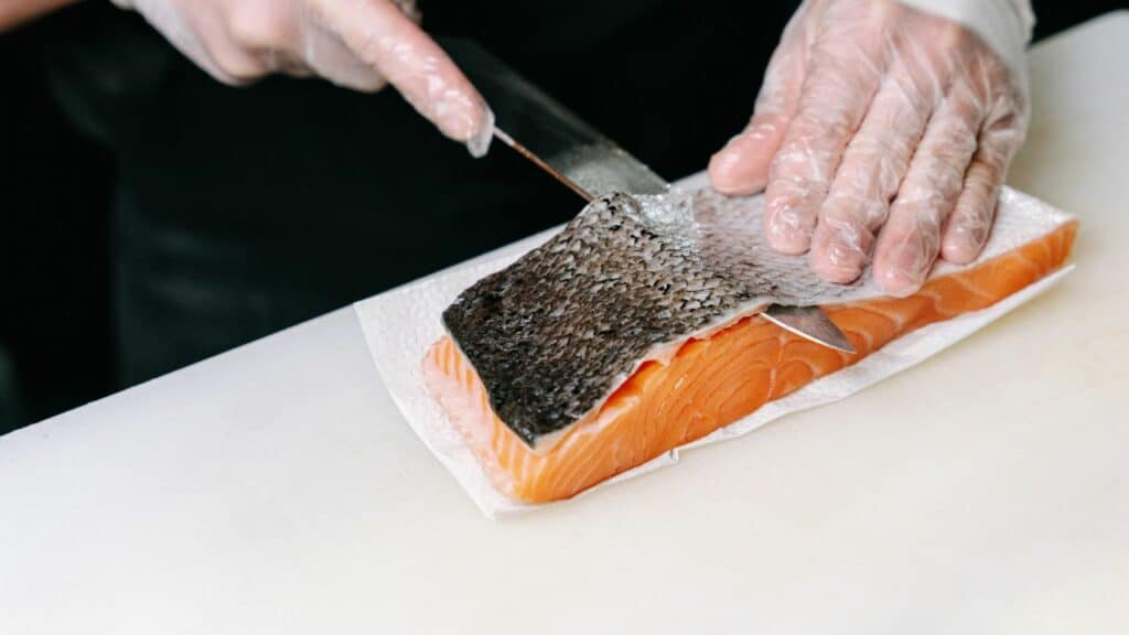 human removes skin from salmon