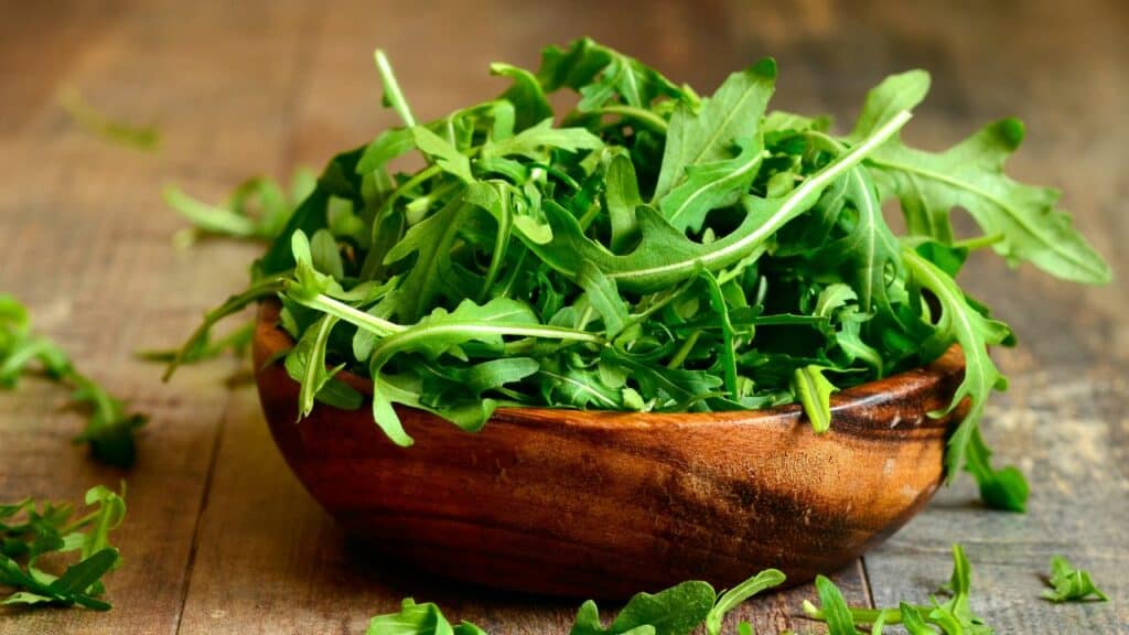 brown wooden bowl with arugula