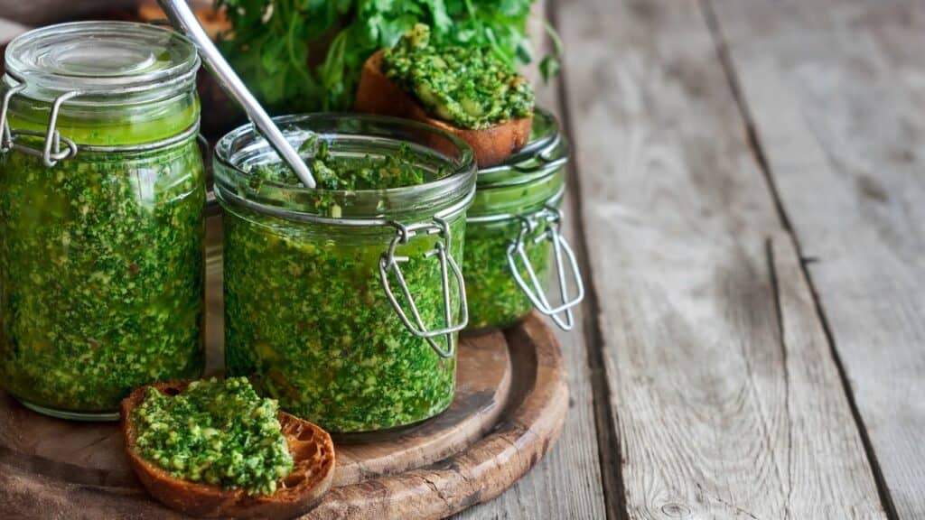 pesto in jars on a wooden plate