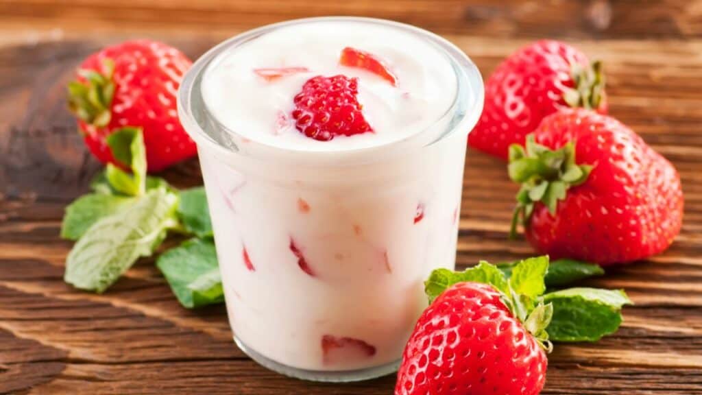 strawberry yogurt in a jar and strawberries around